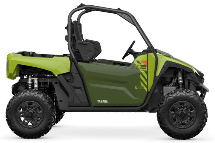 Green off-road vehicle with roll cage and rugged tires, side view.